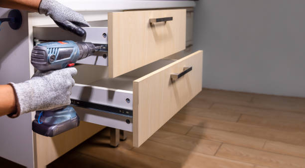 Worker fix over tight drawer slides in kitchen. Concept Fix stuck wooden drawer slides.